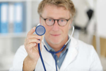 a mature doctor using stethoscopeの写真素材