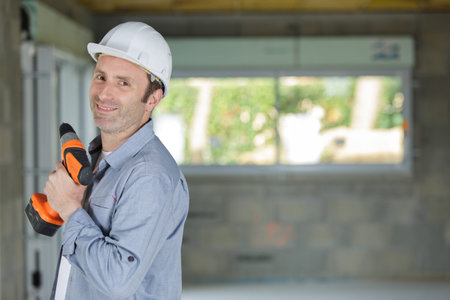 happy man with drill in site