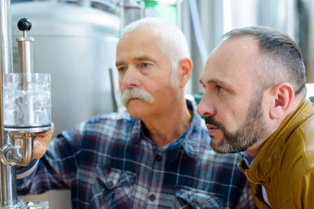 portrait of concentrated men in breweryの写真素材