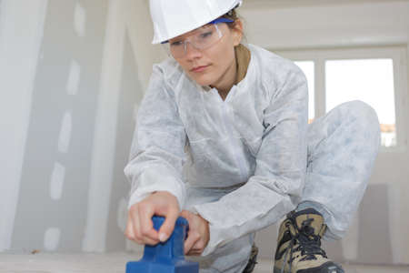 female floor setter sanding the floorの写真素材