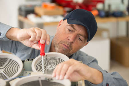 picture of man doing appliance repairの写真素材