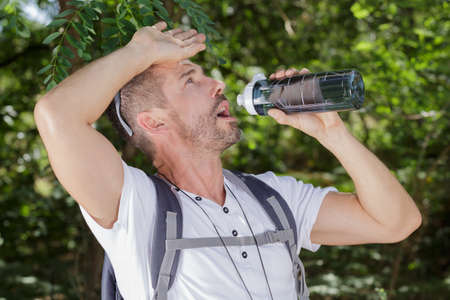 a thirsty hiker drinking waterの写真素材
