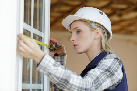 portait of a woman measuring window frame