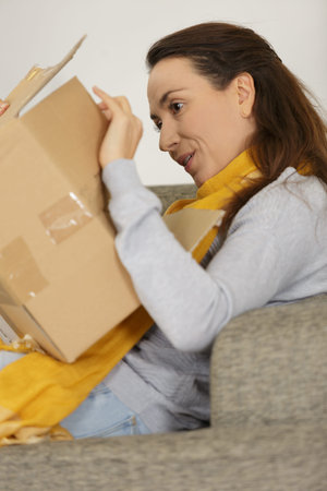 beautiful attractive happy woman opening cardboard boxの写真素材