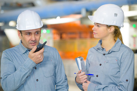 male supervisor using walkie-talkie with female colleague