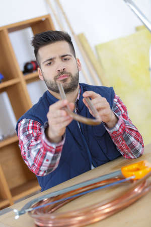 a man sawing transparent tubeの写真素材