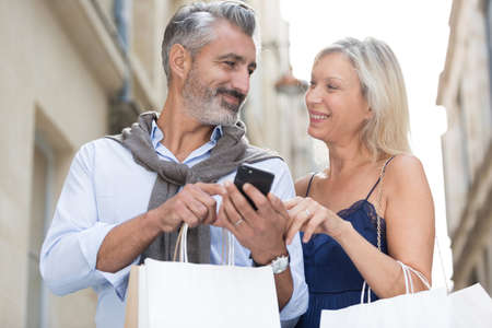 happy couple with shopping bagsの写真素材