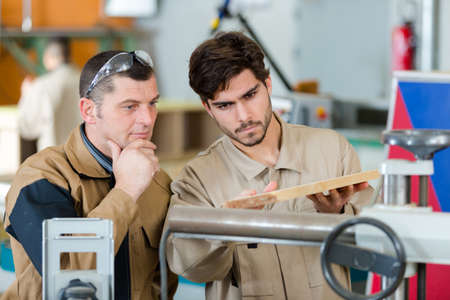 two men in workwear in a carpenters workshopの写真素材