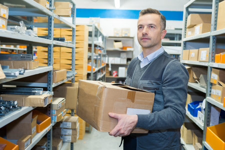man in stores area holding cardboard box