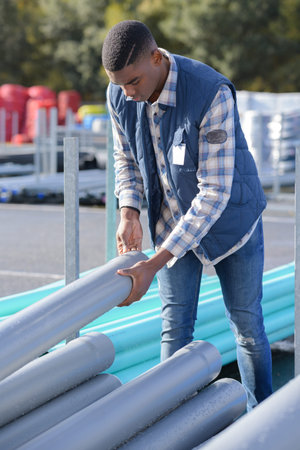 worker selecting plastic tube from stock