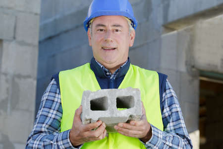 male builder holdind a cement blockの写真素材