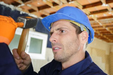 man holding hammer on wall