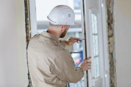 man fixing door handle with screwdriver in a new house