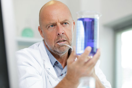 mature male scientist holding test tube in a lab