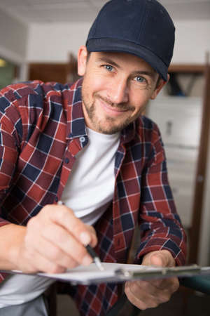 attractive delivery worker looking at cameraの写真素材