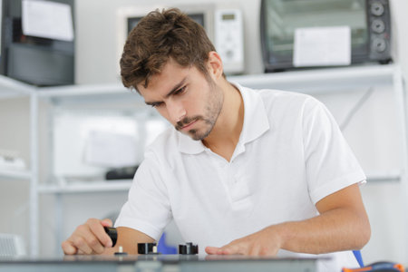young repairman installing induction cooker in kitchen