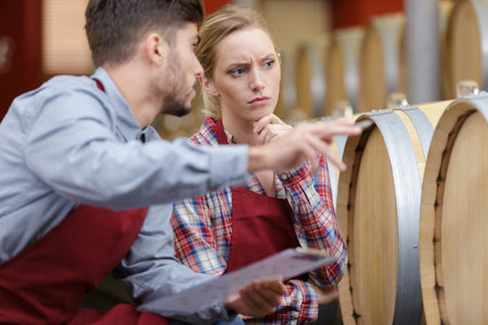 a woman and man working with wine