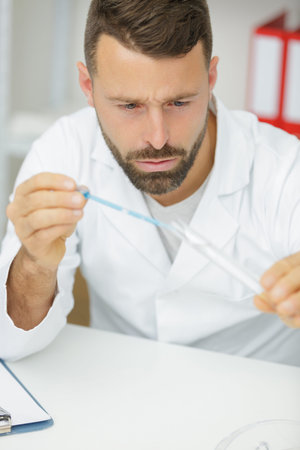 portrait of a man checking blue liquid