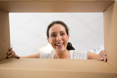 surprised young female opening a carton box