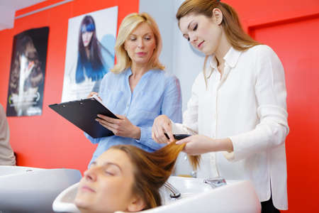 hairdresser and apprentice with customerの写真素材