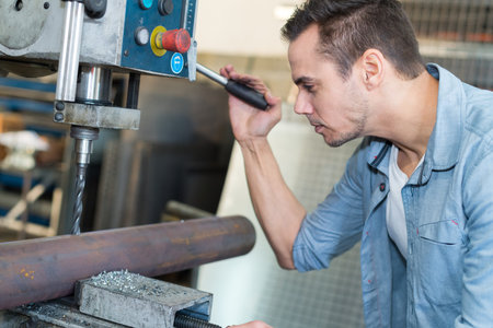 operator drilling a metal rod
