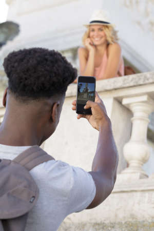 man taking a picture of his girlfiends during holidaysの写真素材