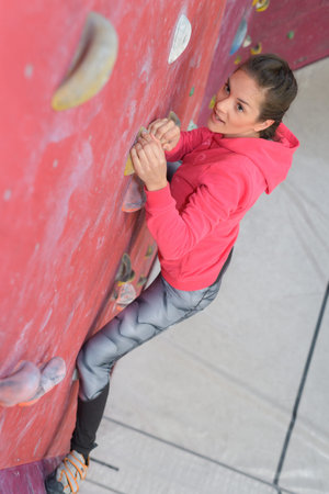 woman ascending indoor climbing wall