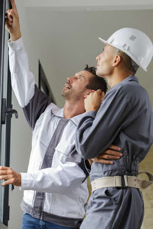 two windows installation workers talkingの写真素材