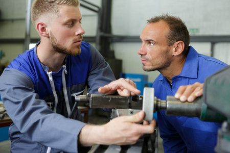 apprentice asking foreman a question while setting up machinery