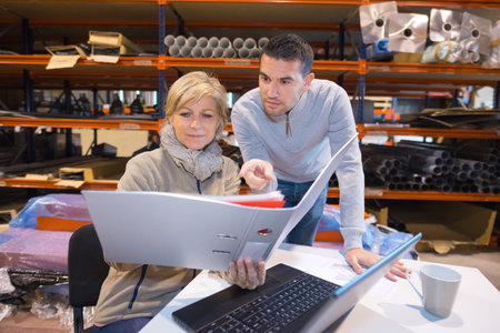 workers studying the folder in the warehouse