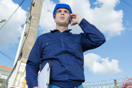 portrait of a male industrial engineer at work using phone