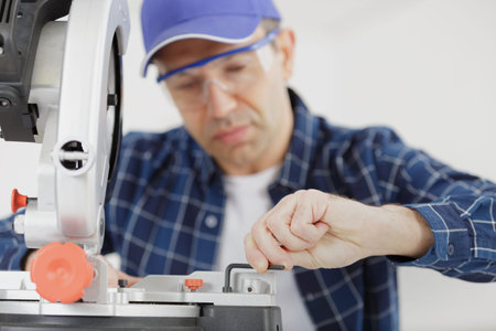 carpenter adjusting the mitter saw
