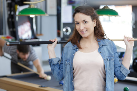 woman playing billiards with her friend