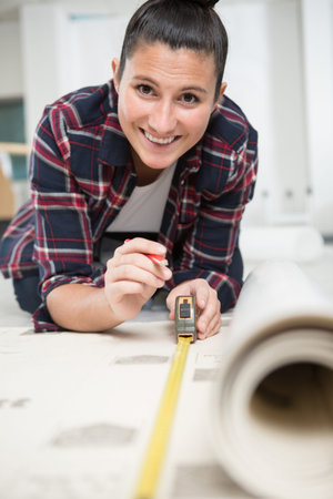 happy female worker measuring a piece of carpet