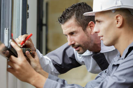 workers working with glass for windowsの写真素材
