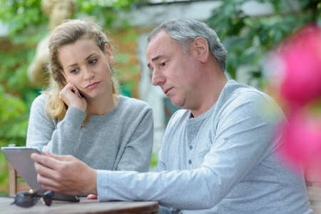 worried man and woman reading some sad newsの写真素材