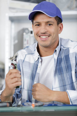 man fixing somthing on white table