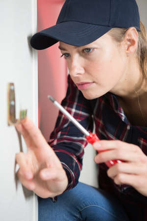 female technician is screwing an electric socketの写真素材