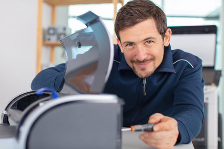 man technician repairing a printer at business place at work
