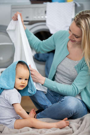 mother folding baby clothes at homeの写真素材