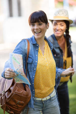 female friends consulting a city mapの写真素材