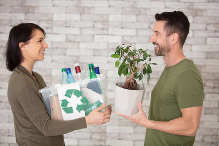 a young couple recycling plastic in their kitchenの写真素材