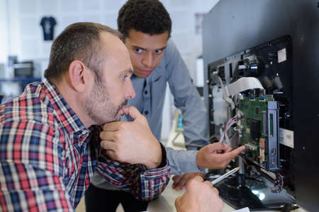 apprentice and teacher during television repairationの写真素材