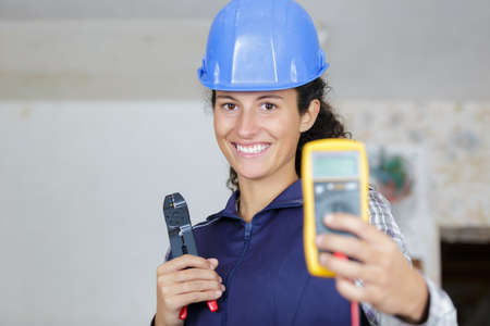 happy woman measuring electrical currentの写真素材