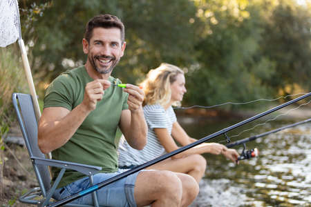 young couple is enjoying fishing on sunny dayの写真素材