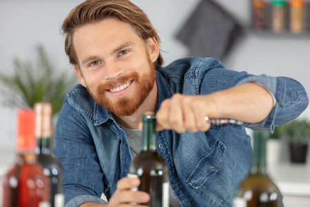 male open wine bottle with corkscrewの写真素材