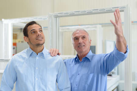 engineer controlling other wokers job in factoryの写真素材