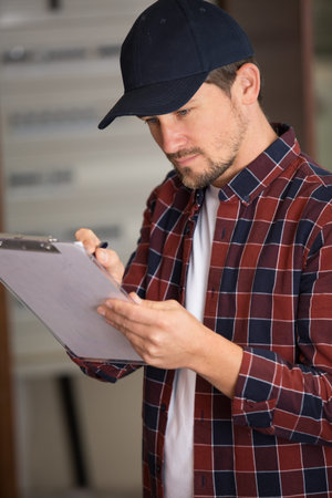 male technician holding clipboard and pen