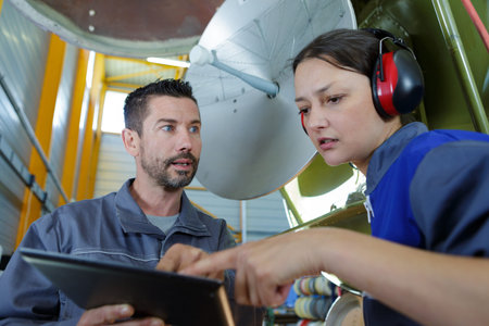 engineers checking a parabolic dish television antennae