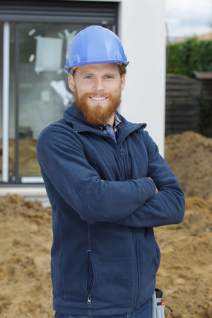 confident mid adult manual worker with arms crossed